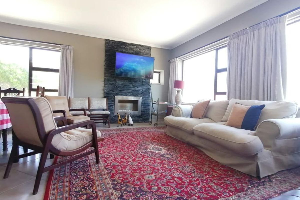 Spacious living room featuring a prominent stone-clad fireplace feature wall and large windows that provide ample natural light.