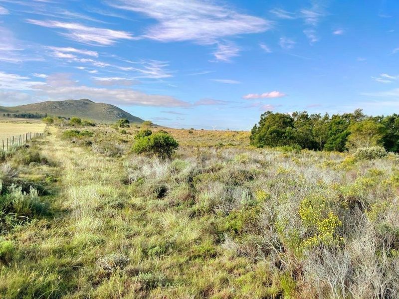 A scenic view of the vacant residential land featuring natural vegetation, rolling hills, and wire fencing along the property boundary.