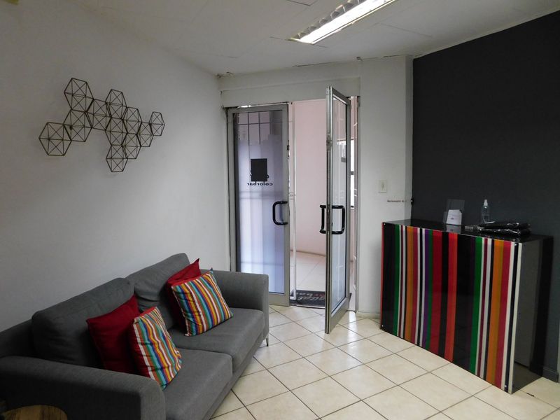 Office entrance area featuring glass double doors, ceramic tile flooring, and a functional reception space.