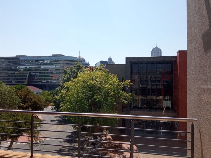 An elevated view overlooking the surrounding office park and urban landscape, featuring a modern stainless steel balustrade in the foreground.
