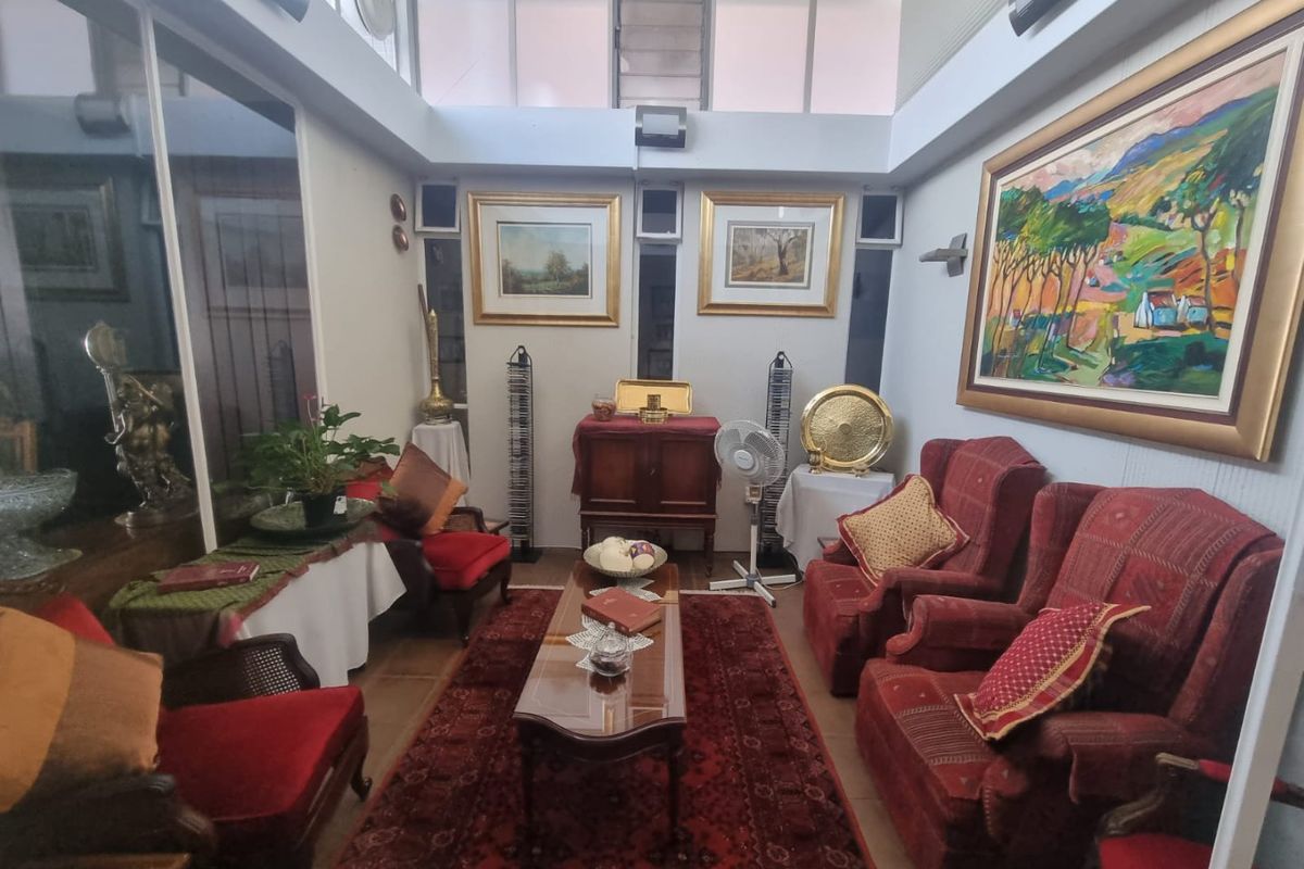 A sun-filled living room featuring high-level windows, tiled flooring, and a bright, airy atmosphere suitable for relaxation.