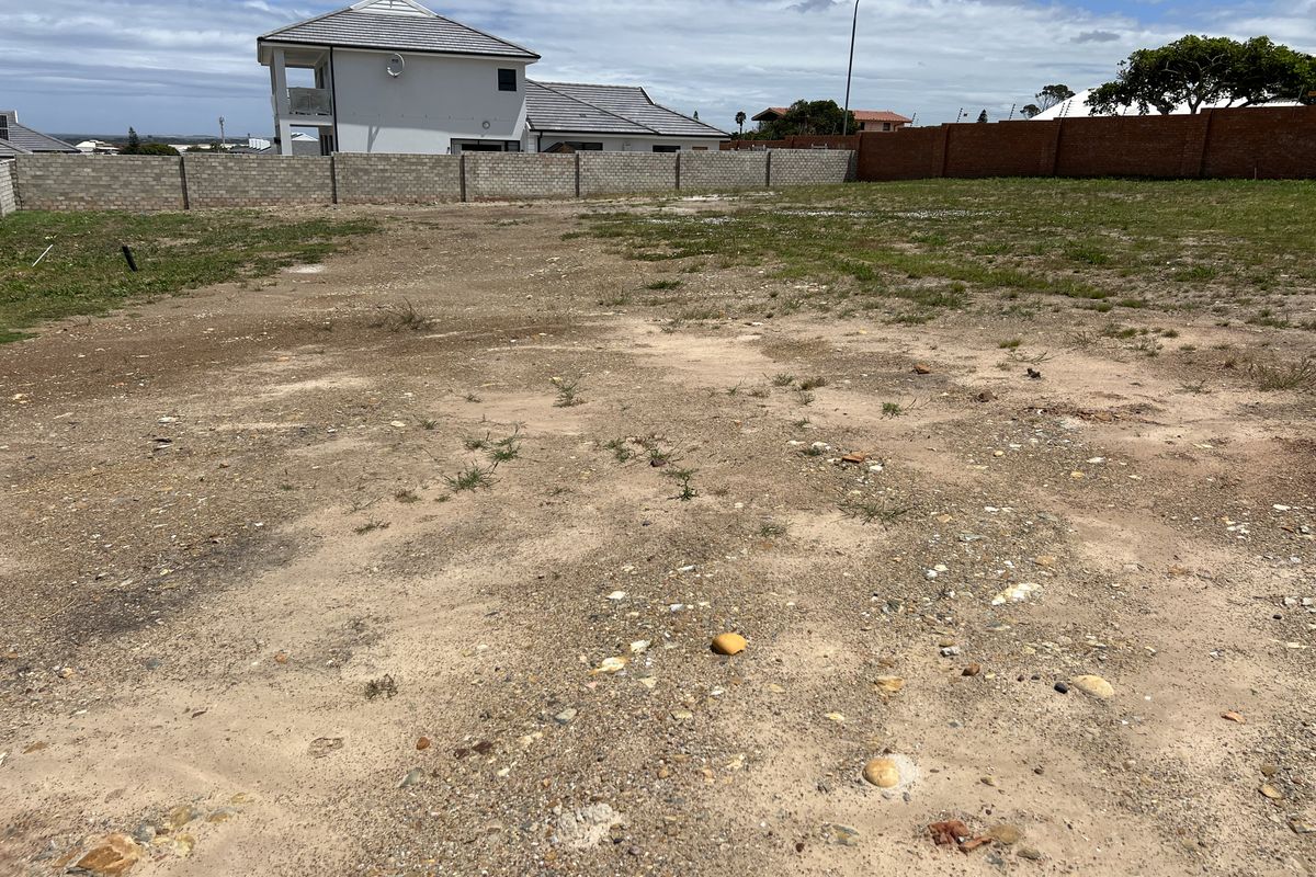 A vacant residential plot featuring a level surface and enclosed by perimeter boundary walls, ready for development.
