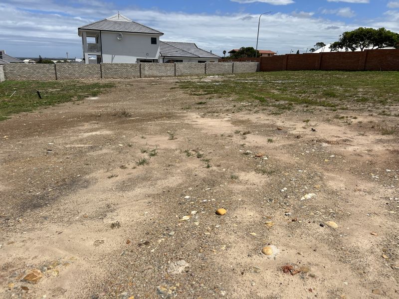A vacant residential plot featuring a level surface and enclosed by perimeter boundary walls, ready for development.