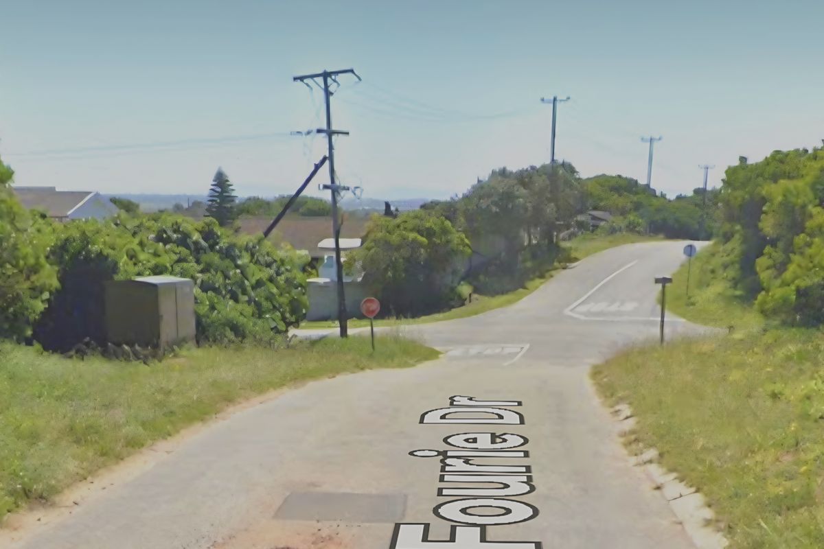 A street view of Fourie Drive showing the intersection, asphalt road surface, and surrounding utility infrastructure.