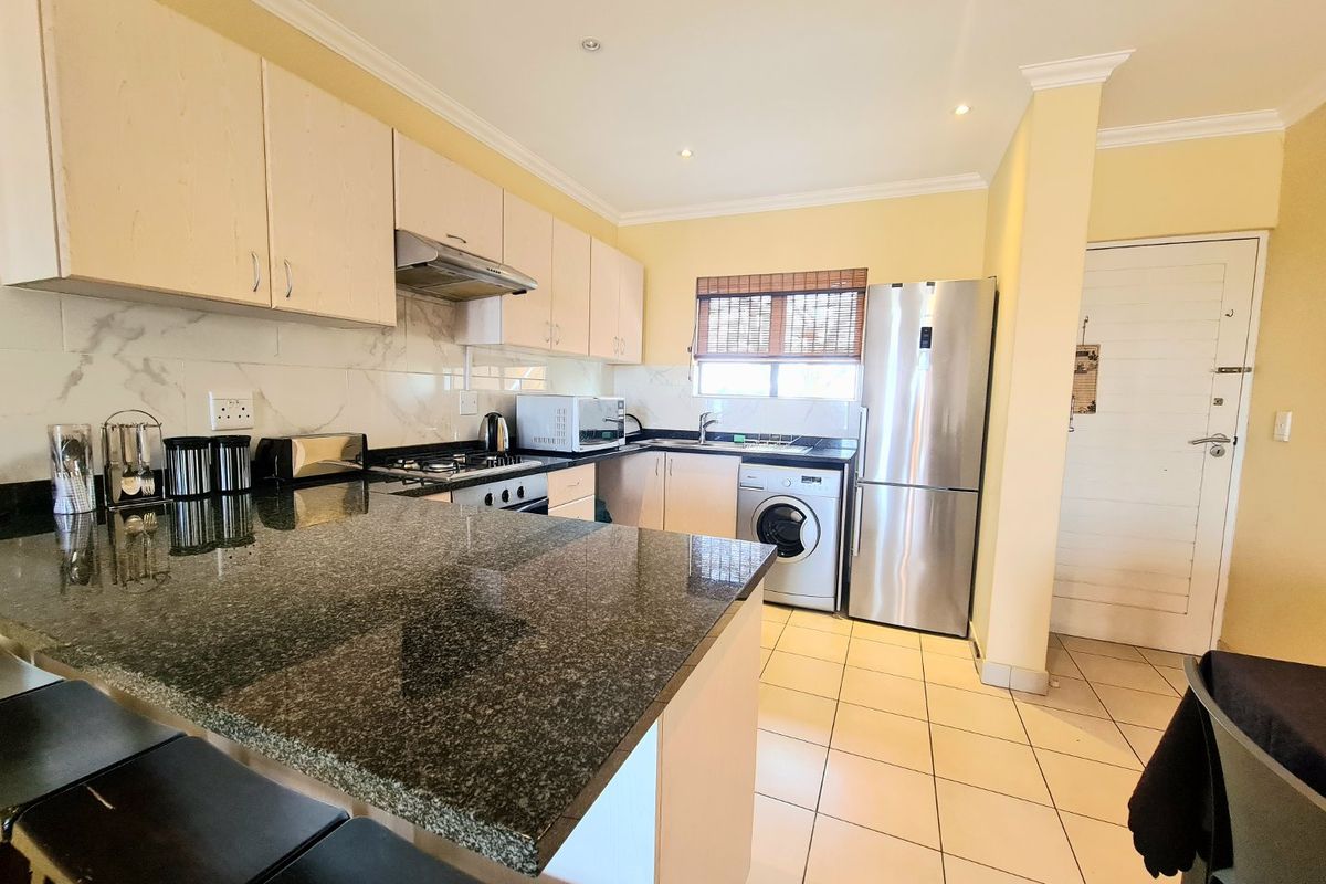 A functional kitchen featuring granite countertops, built-in cabinetry, stainless steel appliances, and tiled flooring with recessed lighting.