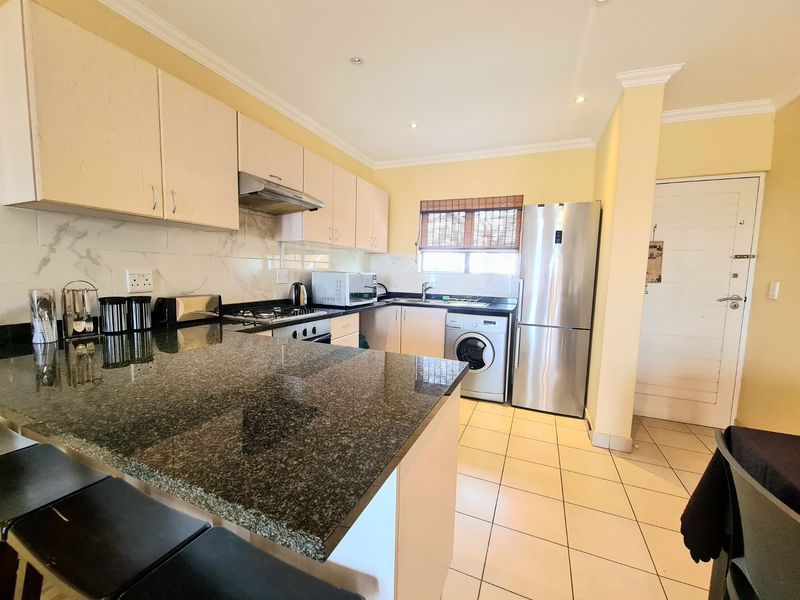 A functional kitchen featuring granite countertops, built-in cabinetry, stainless steel appliances, and tiled flooring with recessed lighting.