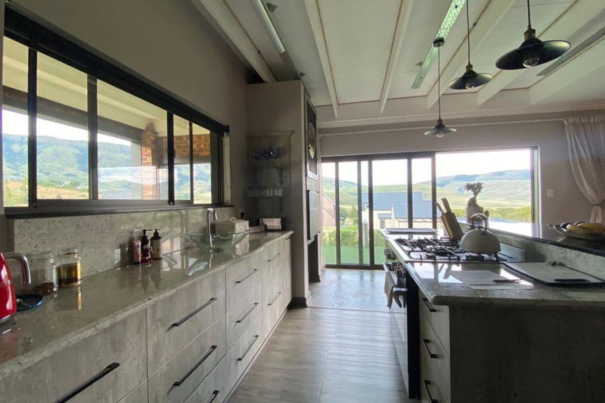 Modern kitchen featuring granite countertops, a built-in gas hob, and expansive sliding doors that provide natural light and scenic views.