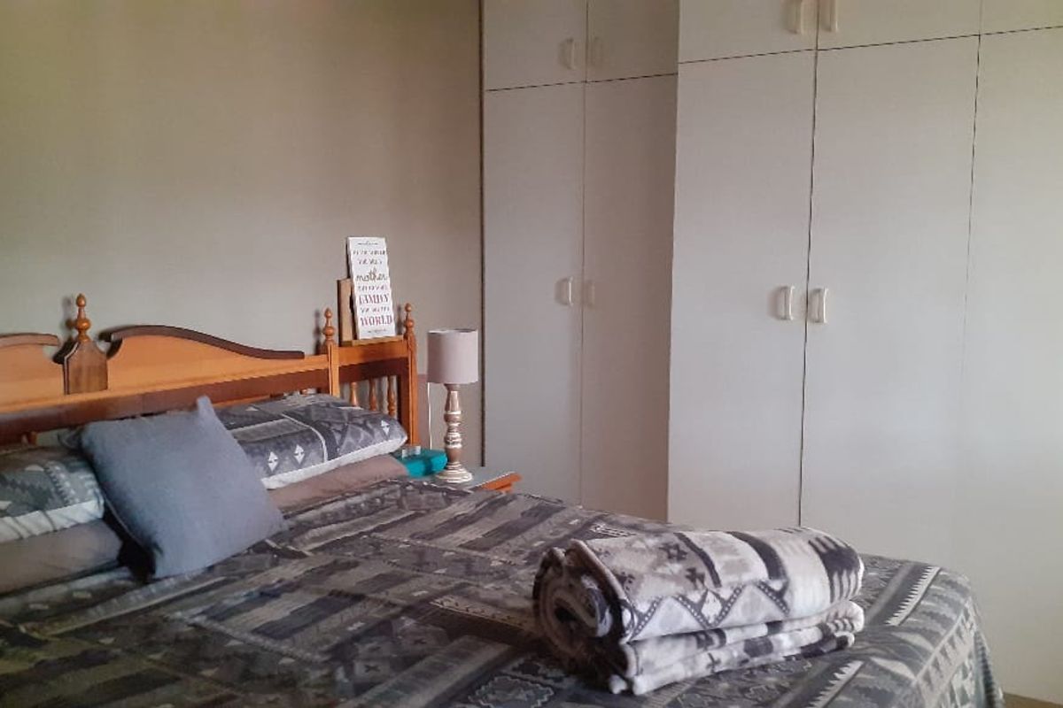 A bedroom featuring ample built-in cupboard storage space.