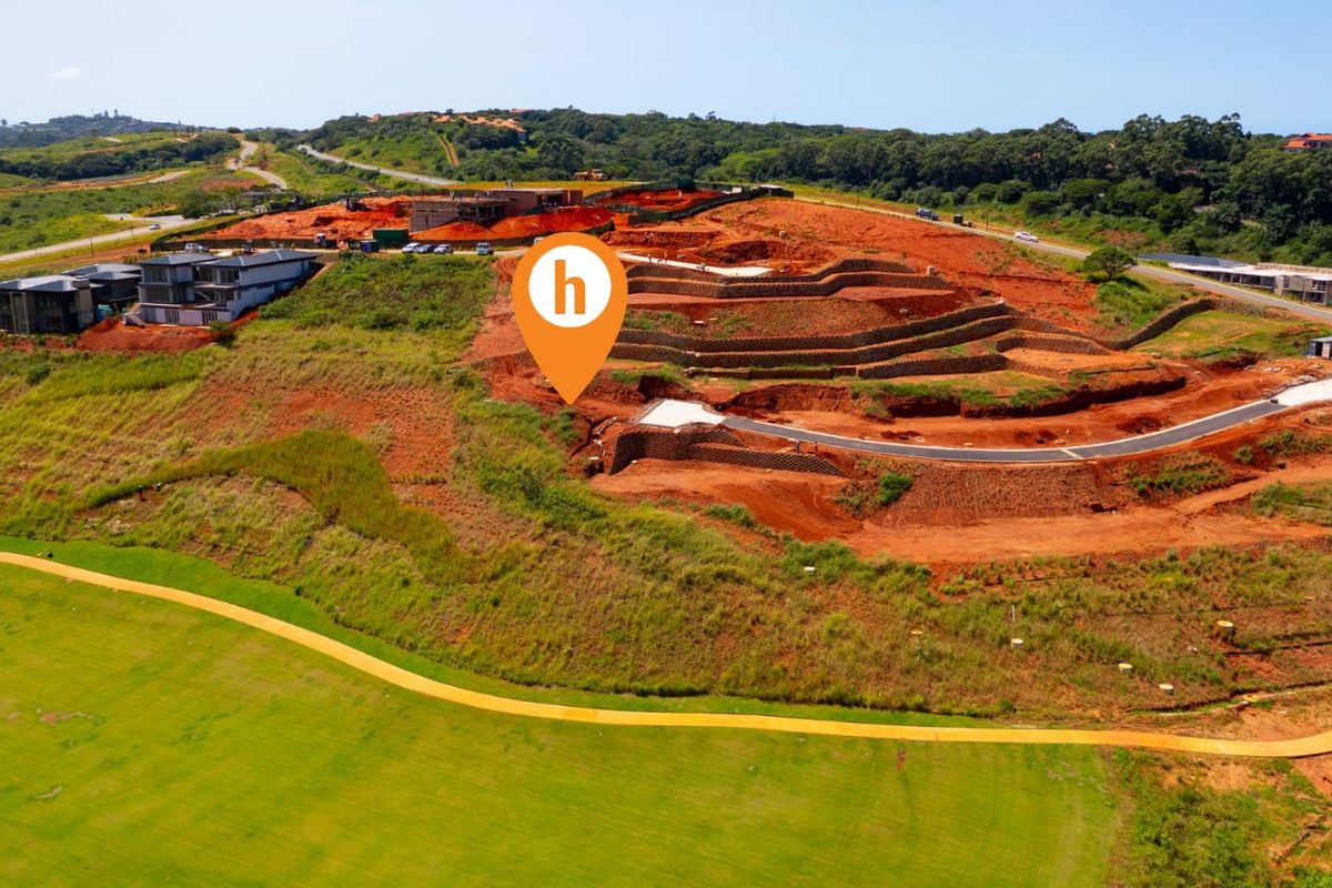 Aerial view of a residential development site featuring terraced earthworks, retaining walls, and newly constructed paved access roads within a landscaped estate.