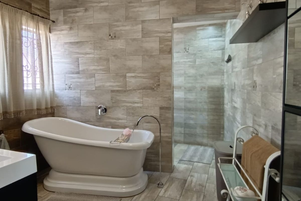 Modern bathroom featuring a freestanding bathtub, walk-in shower, and contemporary wall tiling.