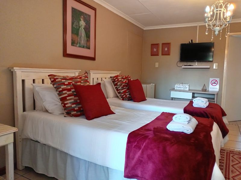 A bedroom featuring tiled flooring, cove cornicing, and a wall-mounted television, presented in a clean and functional condition.