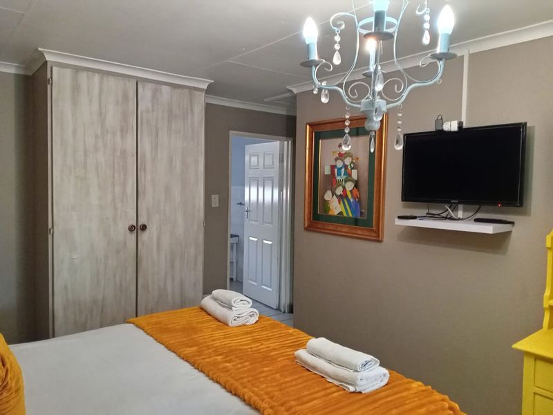 A bedroom featuring a built-in wardrobe, neutral wall tones, and access to an adjoining room.