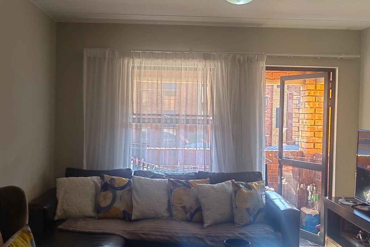 A living room featuring a sliding glass door leading to an outdoor area, with neutral wall tones and standard lighting fixtures.