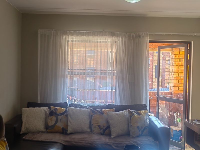 A living room featuring a sliding glass door leading to an outdoor area, with neutral wall tones and standard lighting fixtures.
