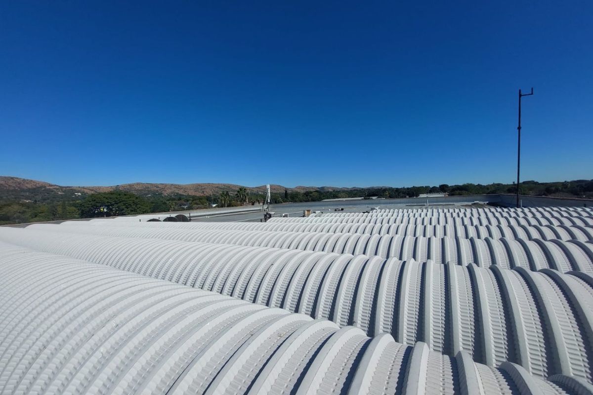 An elevated view of the property's corrugated metal roof structure, showcasing the industrial design and surrounding landscape.