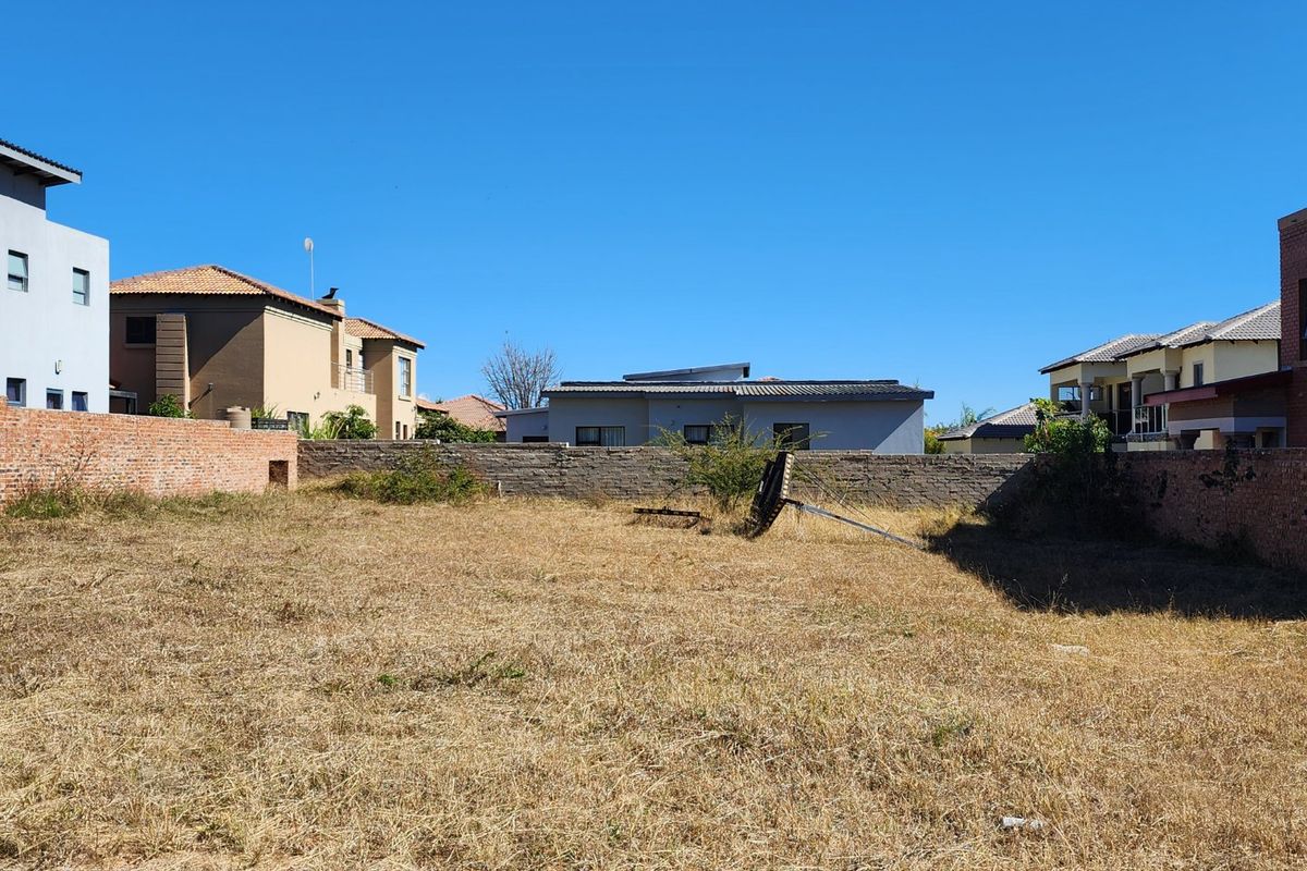 A vacant residential plot enclosed by brick boundary walls, offering a blank canvas for new construction in an established neighbourhood.