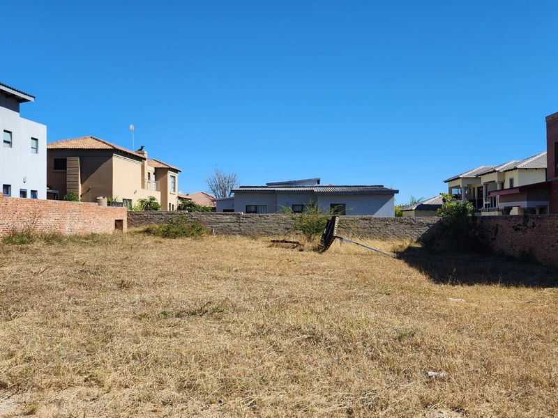 A vacant residential plot enclosed by brick boundary walls, offering a blank canvas for new construction in an established neighbourhood.