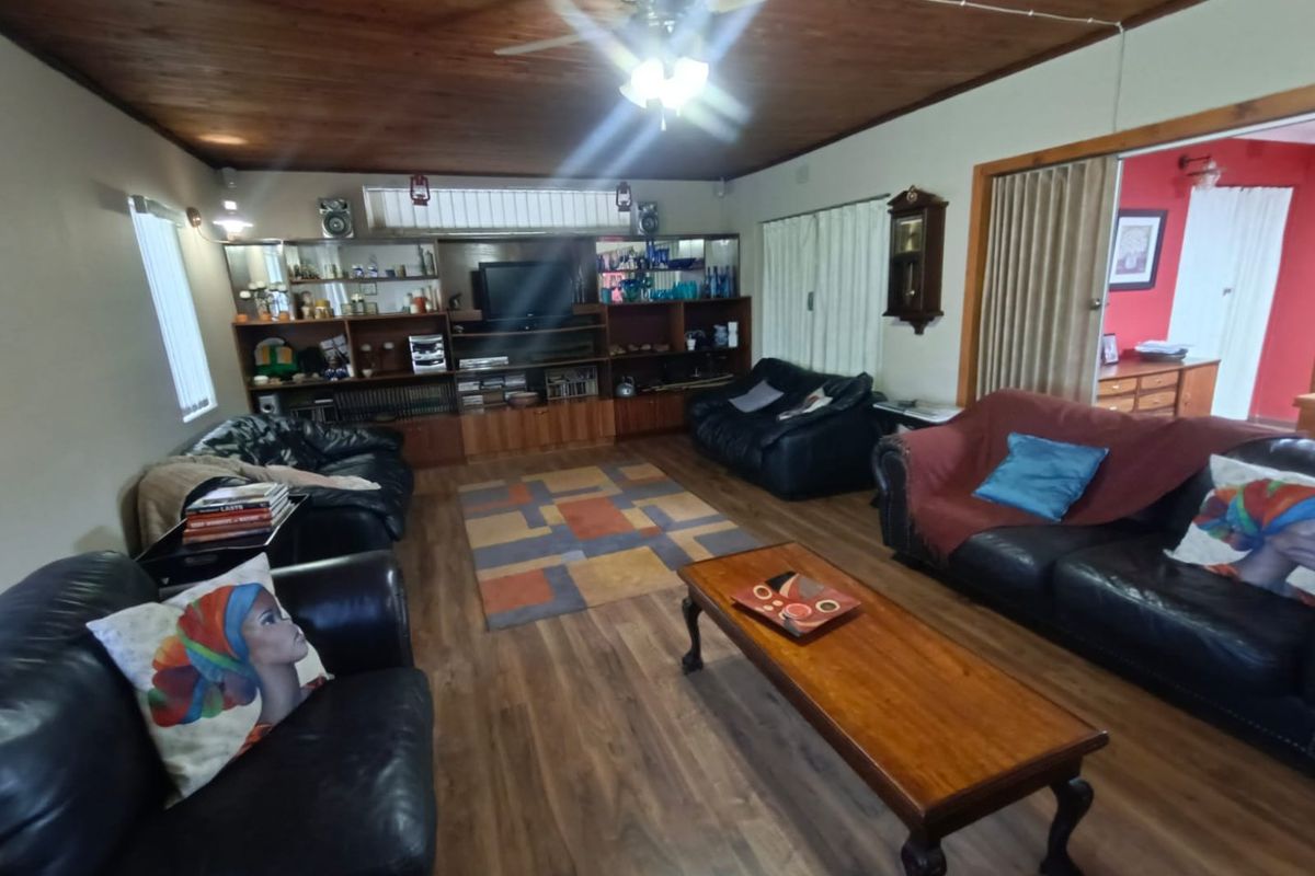 Spacious living room featuring wood-paneled ceilings, built-in cabinetry, and wood-look flooring, providing a comfortable and functional family living space.