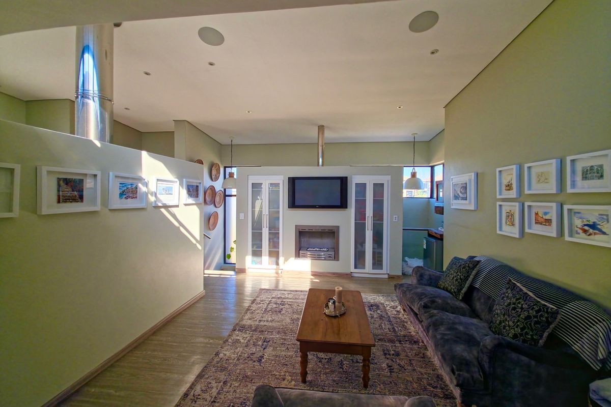 Spacious living room featuring a built-in fireplace, integrated cabinetry, recessed ceiling lighting, and modern flooring.