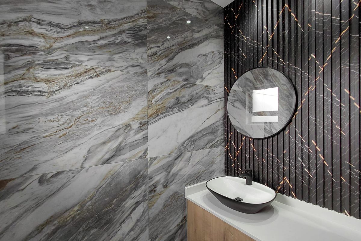 Modern bathroom featuring a sleek vessel sink, stone-look wall tiles, and a decorative slatted feature wall with integrated lighting.