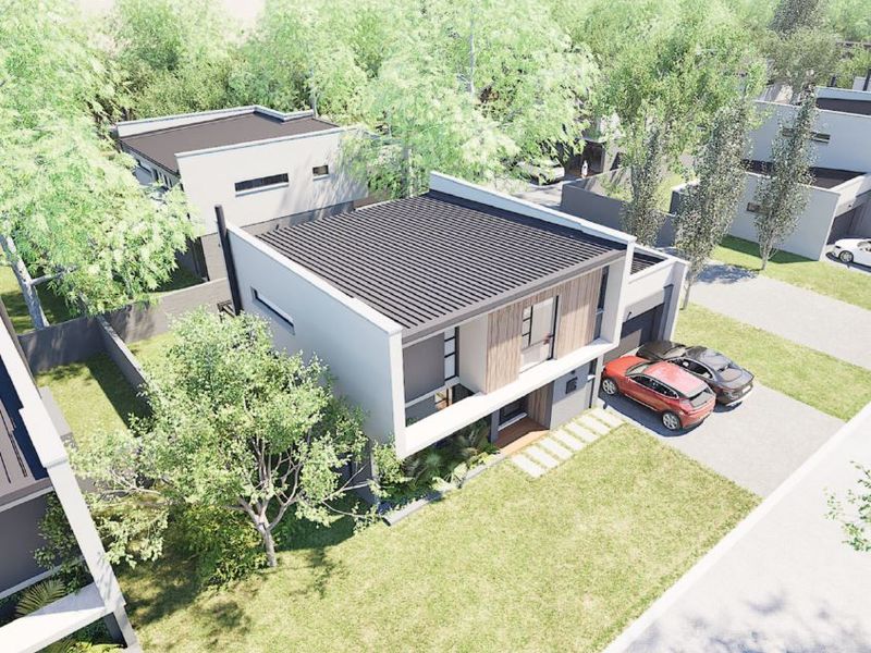An aerial view of a modern two-story residential property featuring a flat roof, contemporary facade, and a paved driveway.
