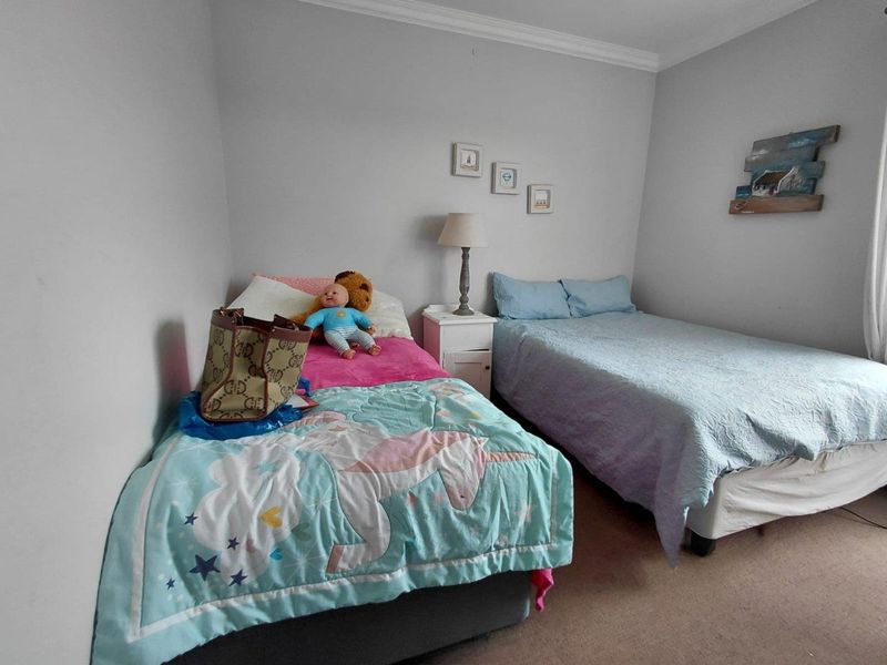 A functional bedroom featuring neutral wall paint and crown molding, providing a comfortable space for rest.