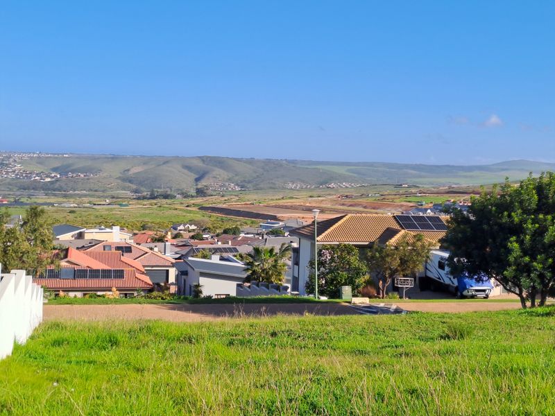 An elevated view overlooking a residential neighborhood with rolling hills in the background.