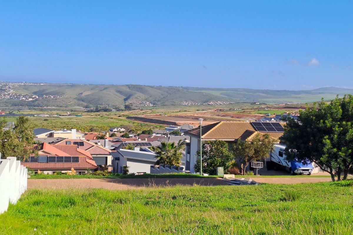 An elevated view overlooking a residential neighborhood with rolling hills in the background.