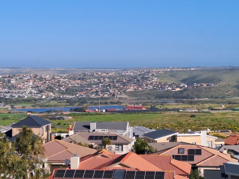 An elevated view overlooking a residential neighborhood with rolling hills and distant landscape in the background.