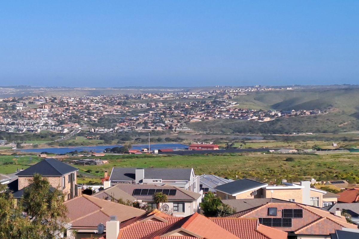 An elevated view overlooking a residential neighborhood with rolling hills and distant landscape in the background.