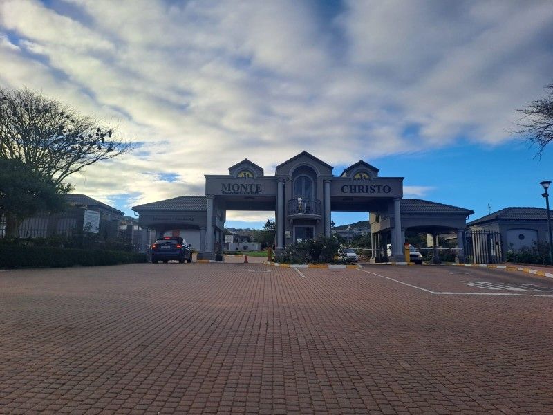 The main entrance gatehouse of the Monte Christo residential estate, featuring a paved driveway and secure access point.