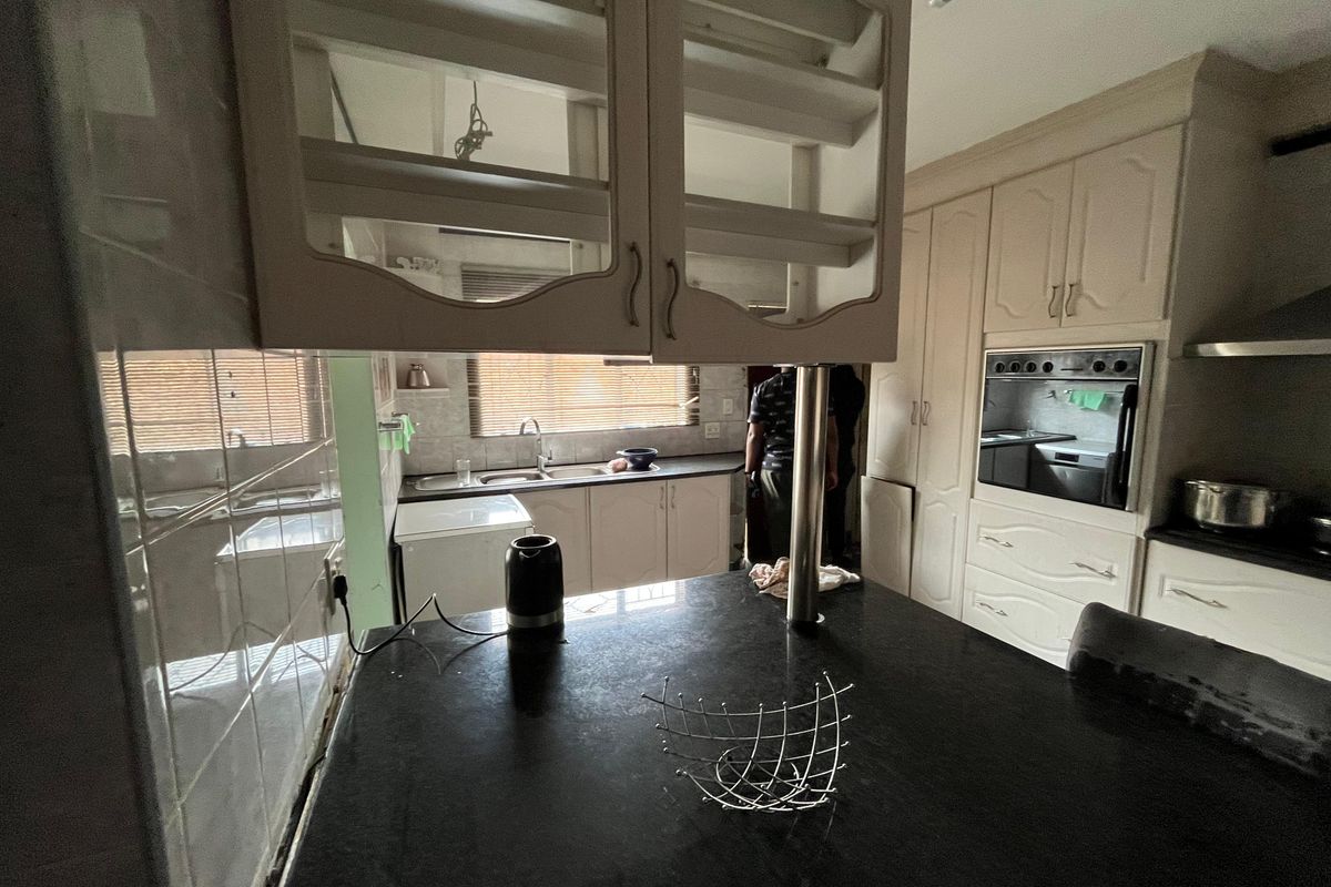 A functional kitchen featuring dark countertops, built-in oven, and ample cabinetry, offering a practical layout for daily meal preparation.