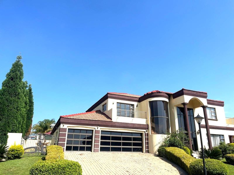 Front elevation of a double-story residence featuring a paved driveway, double garage, and a distinctive curved glass architectural element.