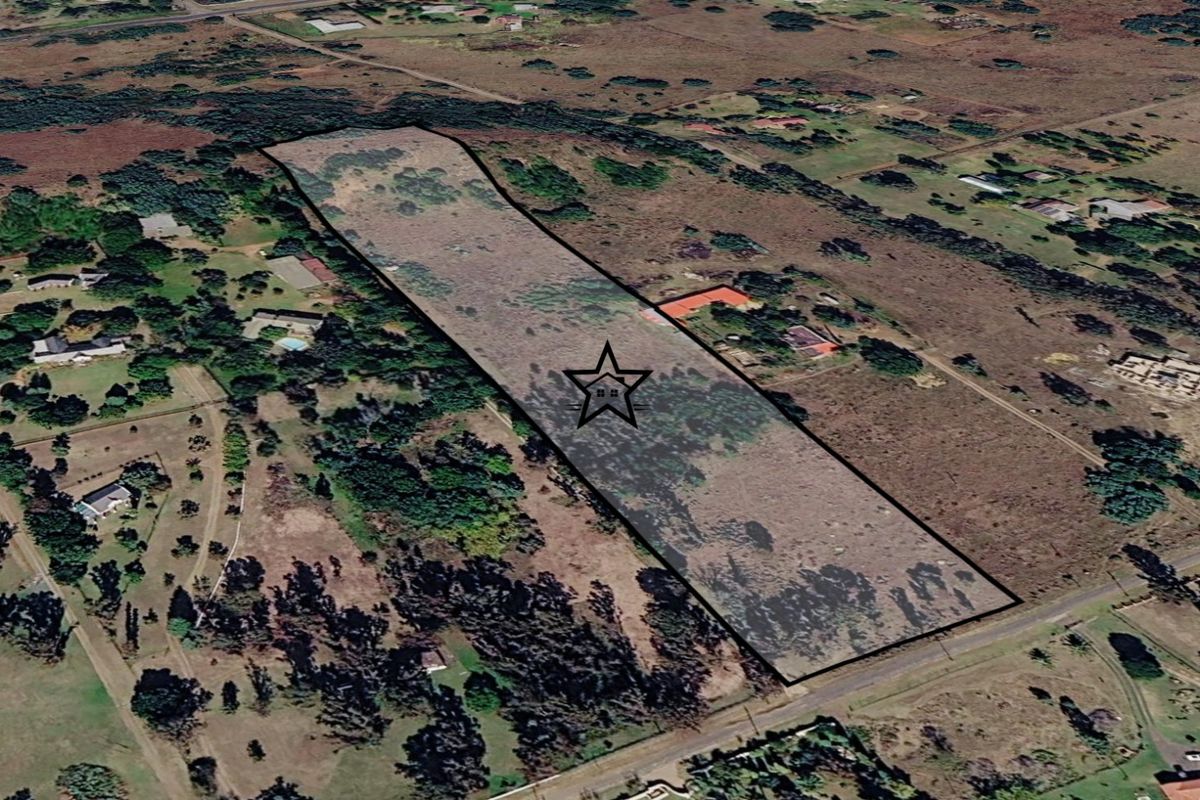 An aerial view of a large, vacant residential plot of land, highlighting its boundaries and surrounding rural landscape.