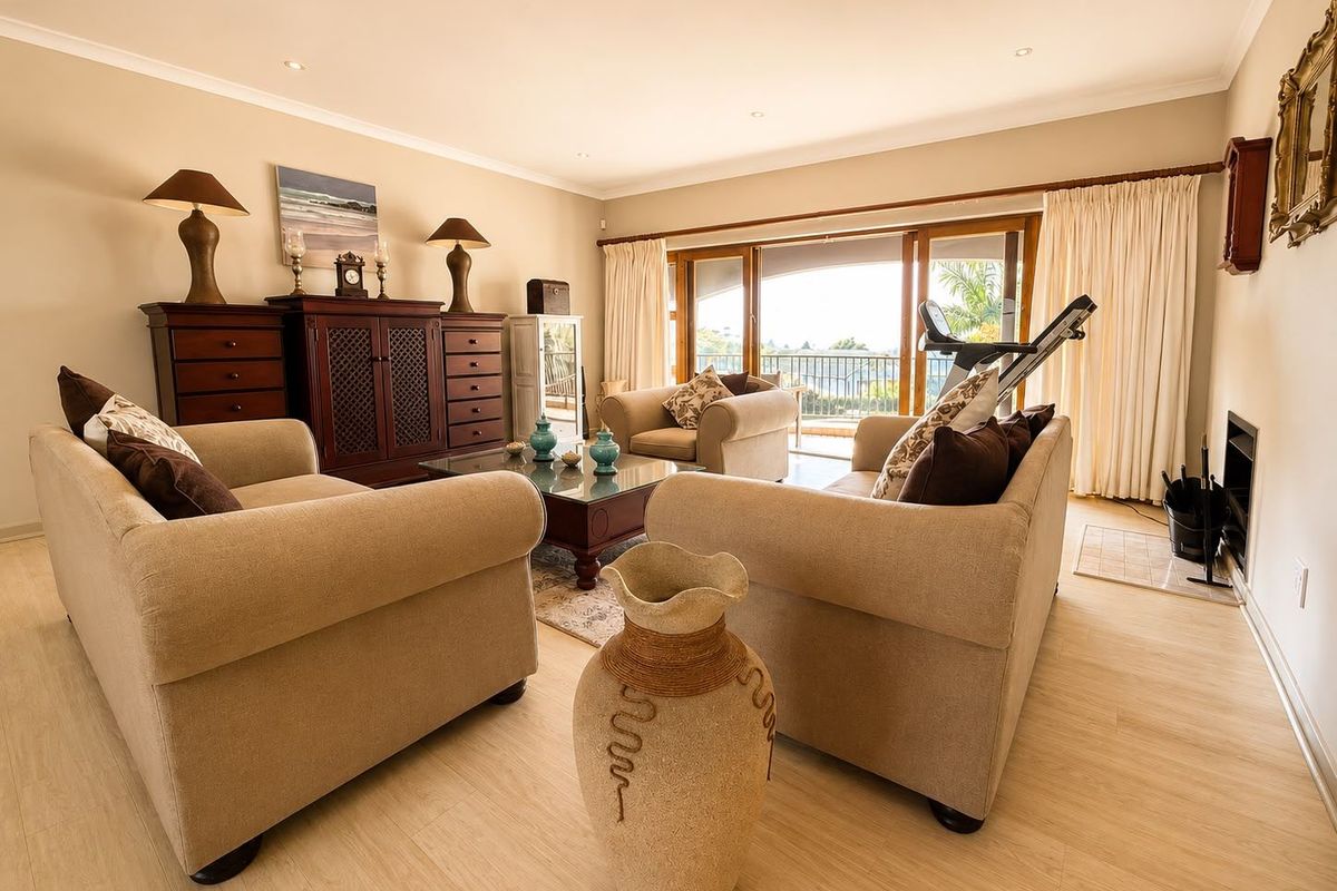 Spacious living room featuring laminate flooring, recessed lighting, and large sliding glass doors that open to an outdoor balcony area.