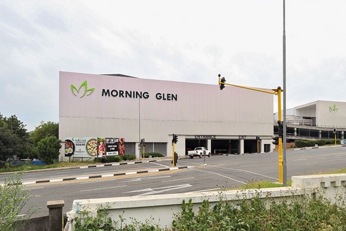 Exterior view of the Morning Glen commercial property featuring a parking garage entrance and prominent signage from the street.
