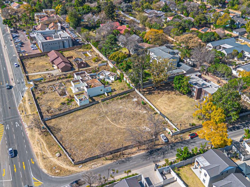 Aerial view of a vacant residential land parcel featuring perimeter walls and existing dilapidated structures in an established suburban neighborhood.