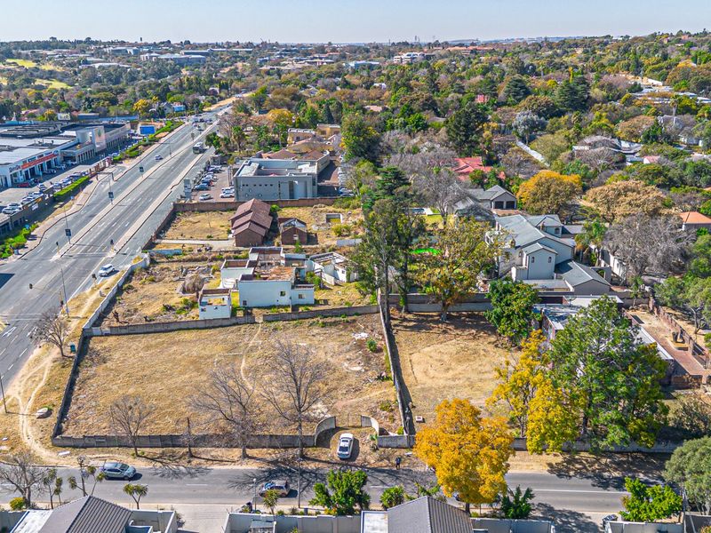 Aerial view of a vacant residential development site featuring boundary walls, mature trees, and existing dilapidated structures, situated in a prime urban location.