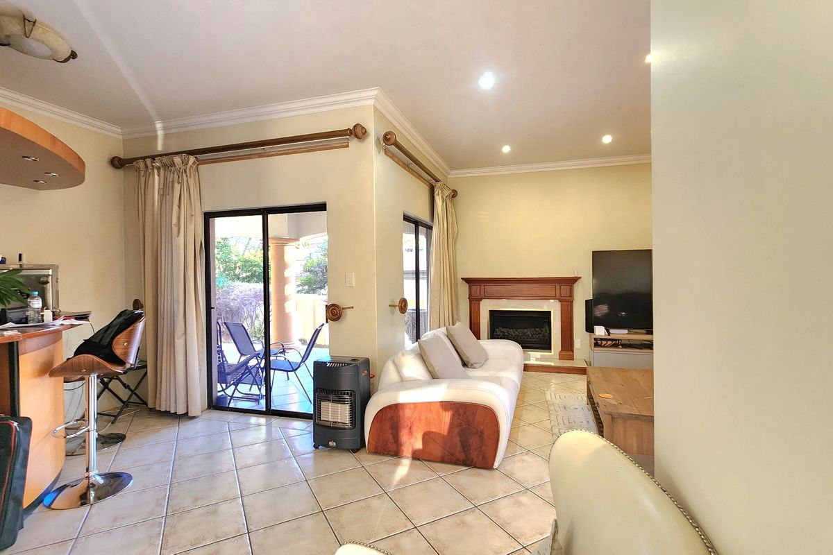 Spacious living room featuring a fireplace, tiled flooring, and sliding glass doors providing access to the outdoor patio area.