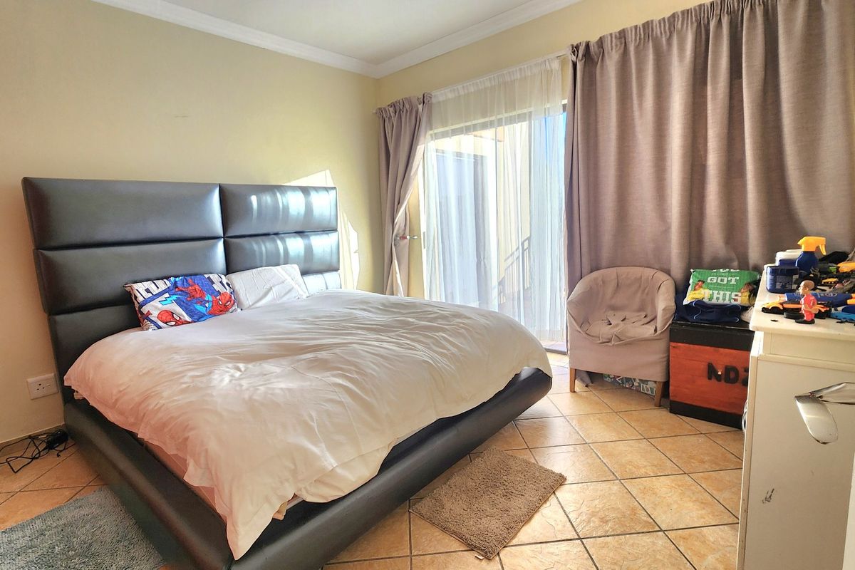 A bedroom featuring tiled flooring and a sliding glass door providing access to the exterior.