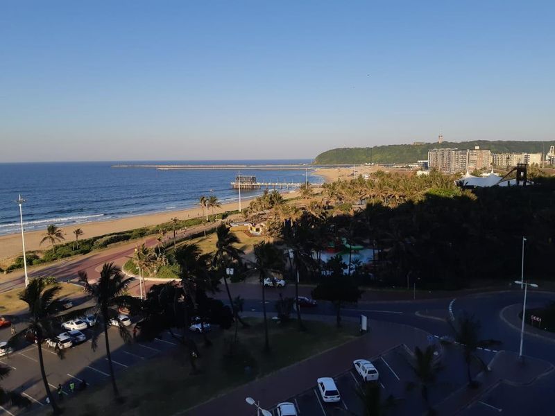 Elevated coastal view overlooking the beach, promenade, and surrounding urban landscape.