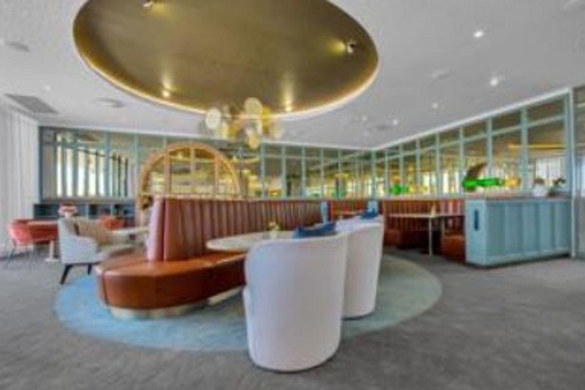 A sophisticated living area featuring elegant mirrored wall paneling, a distinctive circular ceiling feature, and recessed lighting, creating a polished and upscale atmosphere.