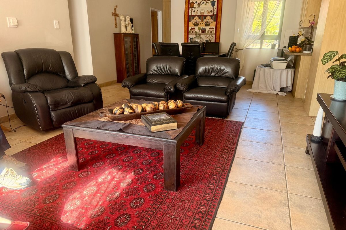 Open plan living and dining area featuring tiled flooring and integrated kitchen cabinetry, providing a functional and connected layout for daily living.
