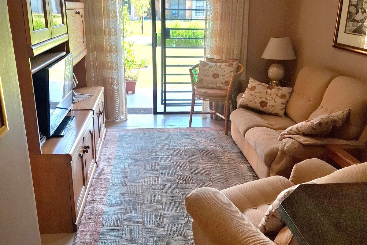 A cozy living room featuring tiled flooring and a sliding glass door that provides direct access to the outdoor area.