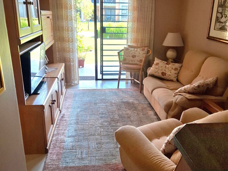 A cozy living room featuring tiled flooring and a sliding glass door that provides direct access to the outdoor area.