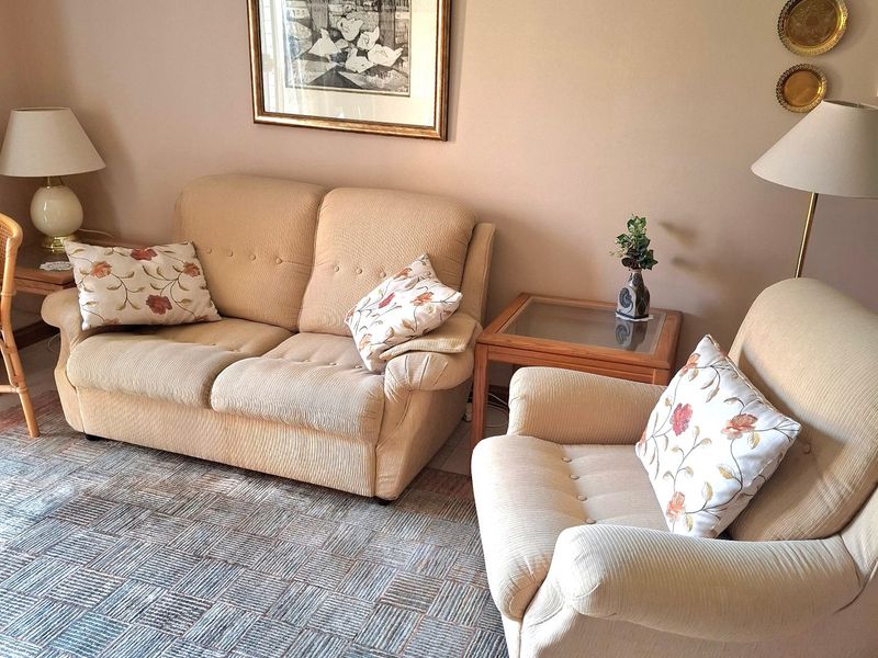 A comfortable living room area featuring neutral wall tones and tiled flooring, providing a functional and inviting space for relaxation.