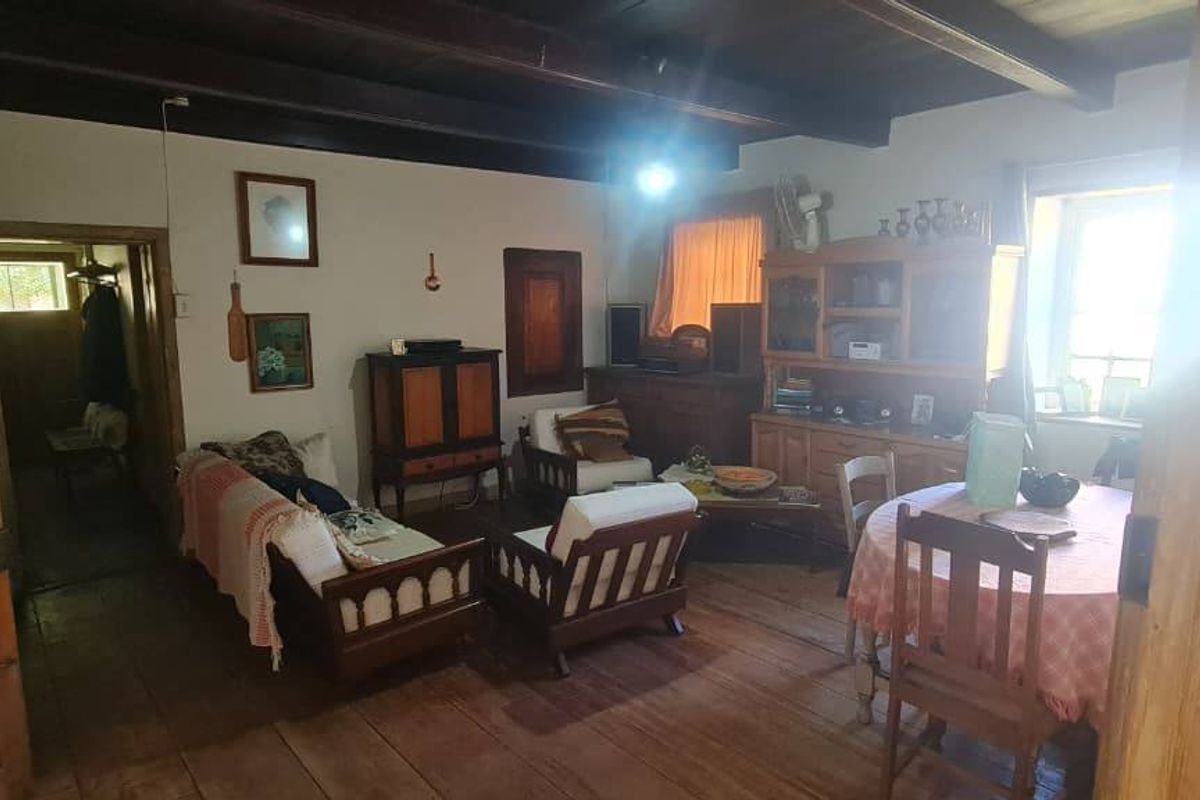 Rustic living room featuring exposed timber ceiling beams and original timber flooring, showcasing a traditional farmhouse aesthetic with potential for cosmetic updates.
