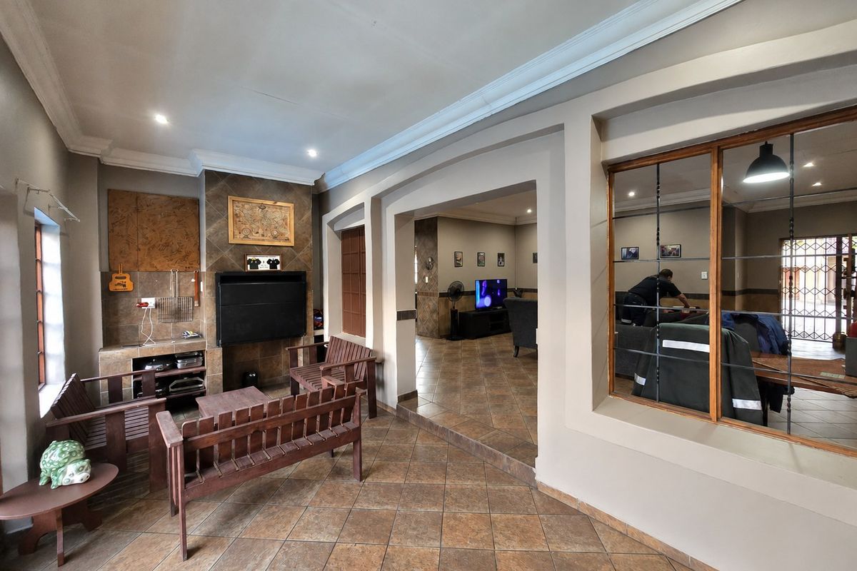 Spacious living area featuring tiled flooring, a built-in fireplace, and an internal window looking into an adjacent room.
