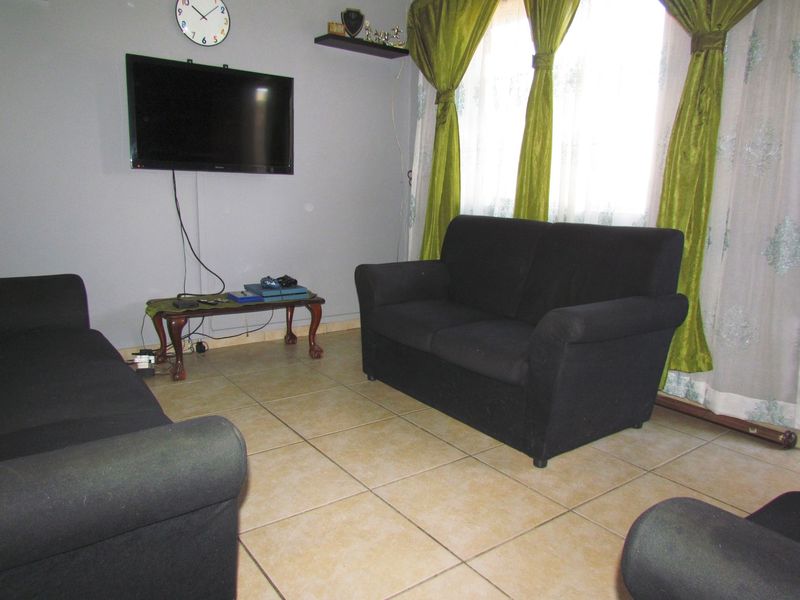 A living room area featuring tiled flooring and neutral wall finishes, providing a functional space for relaxation.