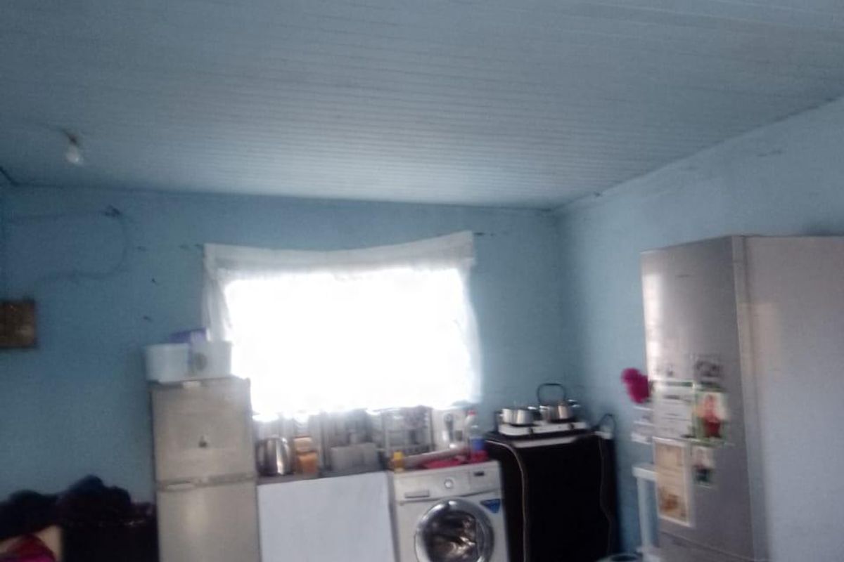 A functional laundry area featuring tiled flooring and a timber-look ceiling, requiring cosmetic updates to improve the overall aesthetic and condition.